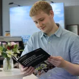 A student reading the three year impact report